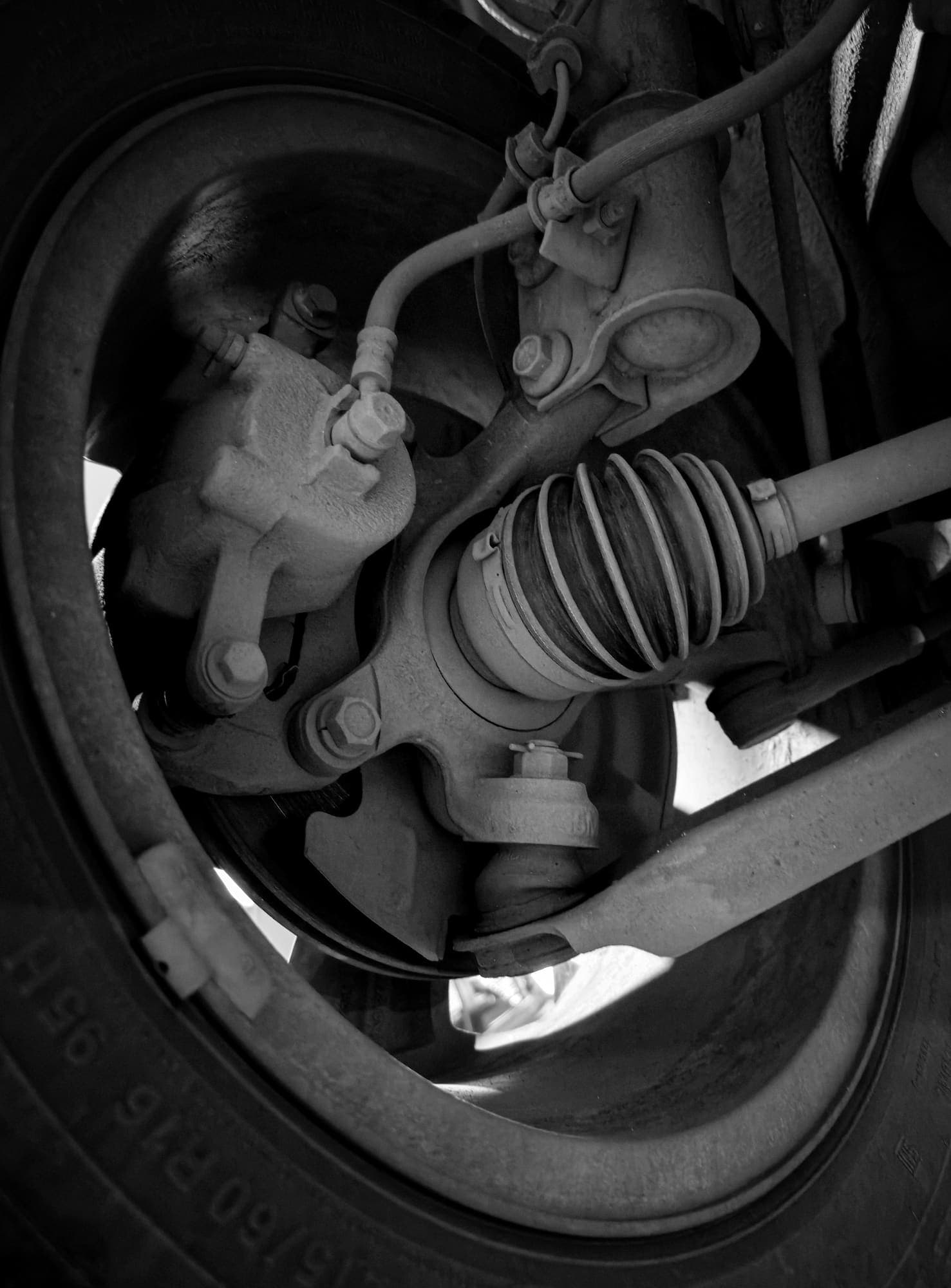 Close-up of a vehicle suspension assembly being inspected in a workshop
